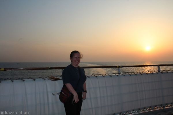 Karen at sunset on the Queen Mary 2 (one of only two sunsets seen aboard!)