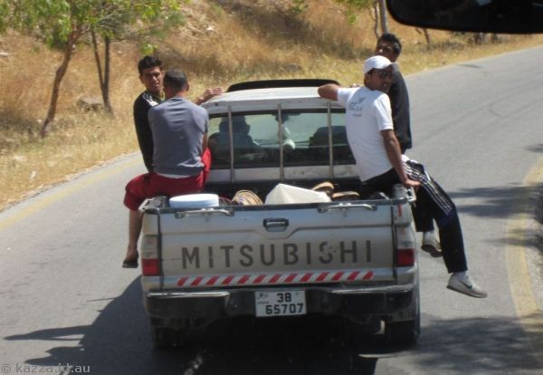 Guys riding on the side of a ute<br/>Photo by Mum
