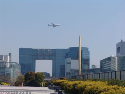Plane coming into land at Haneda airport, with the Telecom Building and the Flame of Freedom