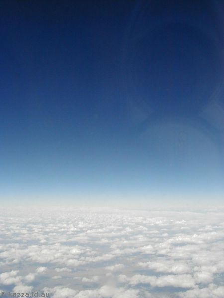Blue sky!<br>Just the horizon for a fun photo, but you can see the reflection of my camera in the plane window