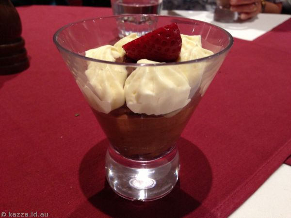 Dark chocolate mousse with whipped cream and strawberries