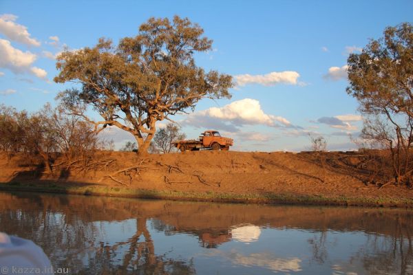 Old truck and reflections on the river near sunset
